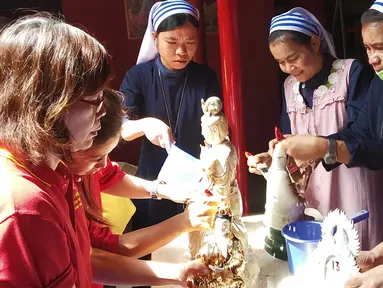 Suster Katolik bersama pengurus vihara membersihkan patung dewa dewi di Vihara Kwan In Thang, Pondok Cabe, Tangerang Selatan, Rabu (30/1). Pembersihan patung dewa dewi itu merupakan salah satu tradisi menyambut Tahun Baru Imlek. (Merdeka.com/Arie Basuki)