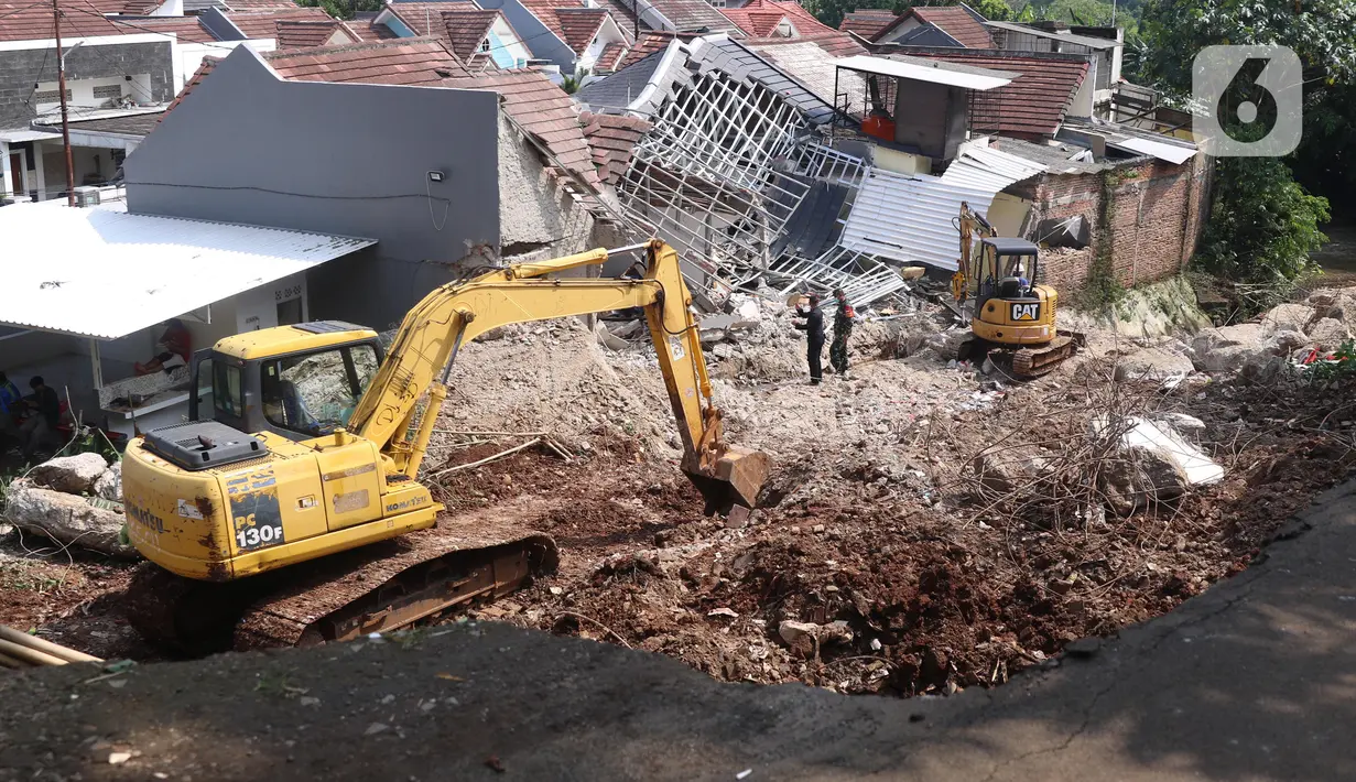 Alat berat berada di rumah yang hancur tertimpa tanah longsor di Perumahan Nerada Estate Ciputat, Tangerang Selatan, Sabtu (12/6/2021). Tidak ada korban jiwa dalam peristiwa longsor yang menimpa sejumlah rumah akibat hujan deras yang terus menerus di kawasan tersebut. (Liputan6.com/Angga Yuniar)