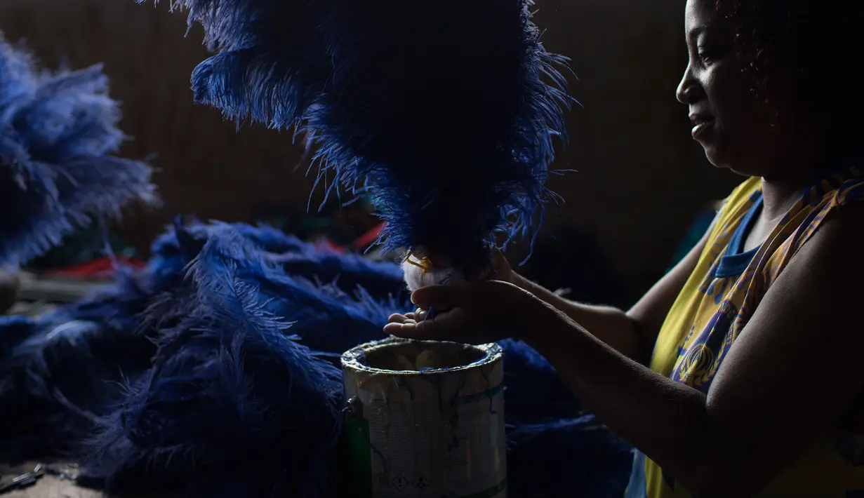 Seorang wanita sedang membuat kostum untuk pertunjukan Karnaval Paraiso do Tuiuti yang akan diadakan di Rio de Janeiro, Brasil (16/1). Tema dalam karnaval di Brasil ini adalah sejarah Brasil dengan perbudakan. (AP Photo / Leo Correa)