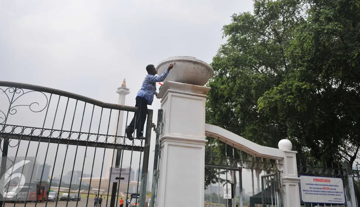 Pegawai pemerintah Provinsi DKI mengecat pagar Monumen Nasional (Monas) di Jakarta, Selasa(10/11). Pengecetan pagar Monas dilaksanakan dalam rangka memperingati Hari Pahlawan yang jatuh pada tanggal 10 November. (Liputan6.com/Gempur M Surya)