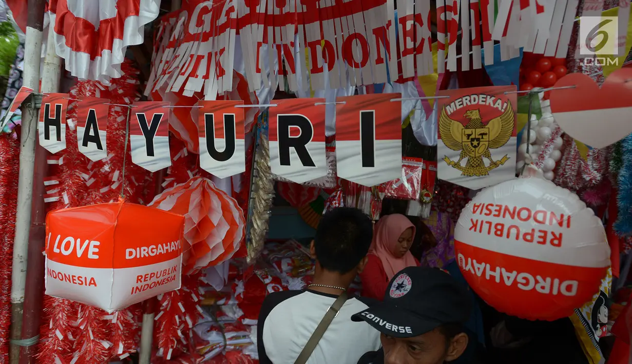 Pedagang bendera melayani pembeli di kawasan Pasar Jatinegara, Jakarta, Rabu (14/8/2019). Pedagang musiman memajang beragam jenis aksesoris seperti bendera merah putih, umbul-umbul dan lambang Garuda untuk perayaan HUT ke-74 RI pada 17 Agustus 2019 mendatang. (merdeka.com/imam buhori)