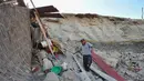 Silverio Apaza berjalan di tengah puing-puing rumahnya yang rusak setelah gempa bumi di Bella Union, Peru, (14/1). Gempa 7,1 skala Richter mengguncang Peru pada Minggu, 14 Januari 2018. (AP Photo / Charlie Reyna)