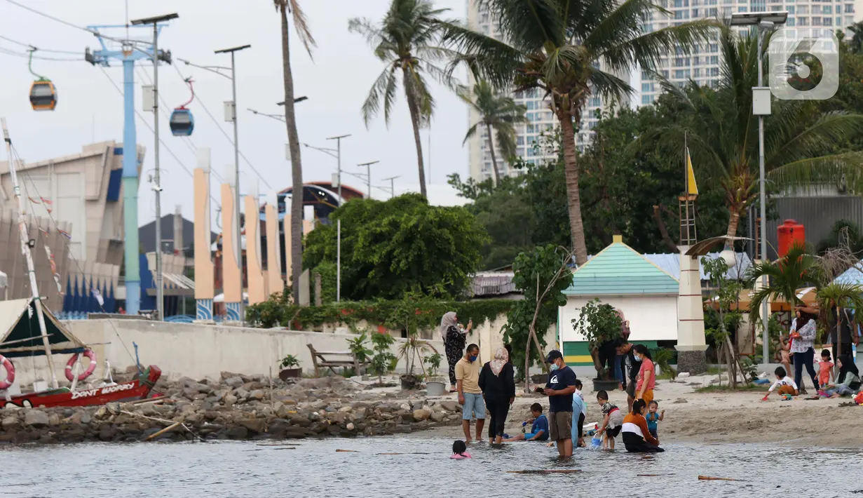 Pengunjung bersama anak-anak menikmati suasana Pantai Indah Taman Impian Jaya Ancol, Jakarta, Kamis (29/10/2020). Libur panjang di masa pemberlakuan PSBB transisi Jakarta dimanfaatkan warga untuk mengunjungi lokasi-lokasi wiisata. (Liputan6.com/Helmi Fithriansyah)