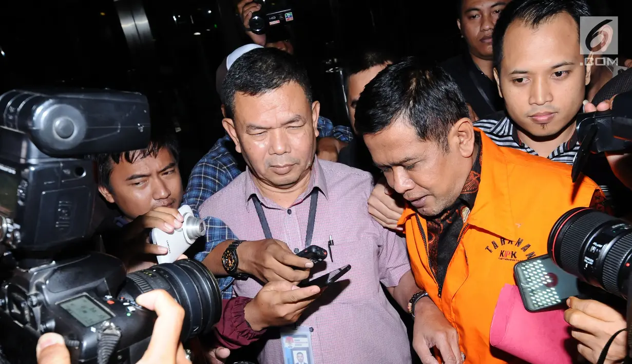 Bupati Nganjuk Taufiqurrahman (tengah) tertunduk saat meninggalkan gedung KPK Jakarta, Kamis (26/10). Taufiqurrahman ditahan KPK melalui OTT terkait dugaan suap perekrutan dan pengelolaan ASN/PNS di Kabupaten Nganjuk. (Liputan6.com/Helmi Fithriansyah)