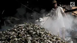 Pekerja membersihkan kerang hijau di kawasan Muara Angke, Jakarta, Rabu (23/1). Selain berimbas pada hasil tangkapan, laut yang tercemar limbah juga mempengaruhi pertumbuhan daging kerang. (Merdeka.com/Iqbal S. Nugroho)