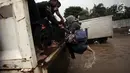 Warga berusaha naik ke truk terbuka ketika banjir merendam di Jalan Boulevard Raya, Kelapa Gading, Jakarta, Kamis (15/2). Hujan yang mengguyur Jakarta mengakibatkan kawasan Kelapa Gading terendam banjir. (Liputan6.com/Arya Manggala)