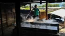 Seorang petani mengolah garam dengan cara tradisional di sebuah tambak di Lamnga, pinggiran Banda Aceh, Aceh, Selasa (7/3/2023). Harga garam rebus kisaran Rp 5.000 per kilogram, sementara harga garam jemur kisaran Rp 2.000 per kilogram. (CHAIDEER MAHYUDDIN/AFP)
