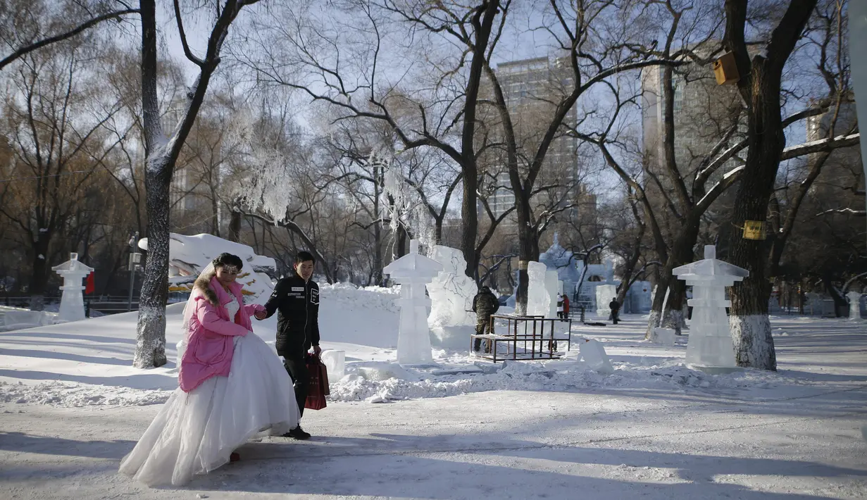 Salah satu pasangan pengantin baru menghadiri upacara pernikahan massal yang merupakan bagian dari Festival Es dan Salju Harbin di provinsi Heilongjiang, China, Rabu (6/1/2016). ( REUTERS/ Aly Song)
