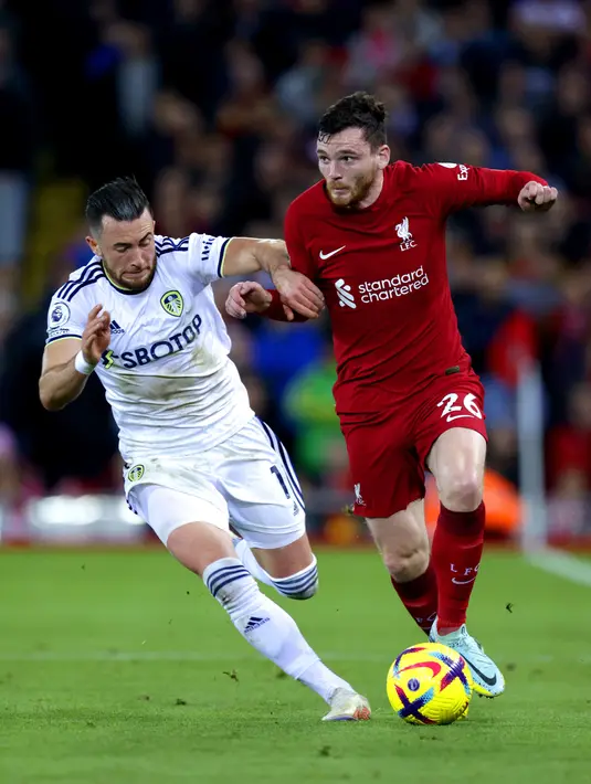 Gelandang Leeds United,  Jack Harrison bersaing dengan bek Liverpool Andrew Robertson pada duel pekan ke-14 Premier League 2022/23 di Anfield, Minggu (30/10/2022) dini hari WIB. Liverpool harus mengakui keunggulan Leeds United dengan skor 2-1 di Anfield. (Richard Sellers/PA via AP)