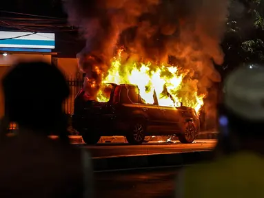 Sebuah mobil terbakar di Jalan Asia Afrika, Jakarta, Kamis (18/3/2021) dinihari. Kobaran api yang melahap mbil jenis minibus bernomor polisi B 1608 SGZ itu menjadi tontonan warga. (Liputan6.com/Johan Tallo)