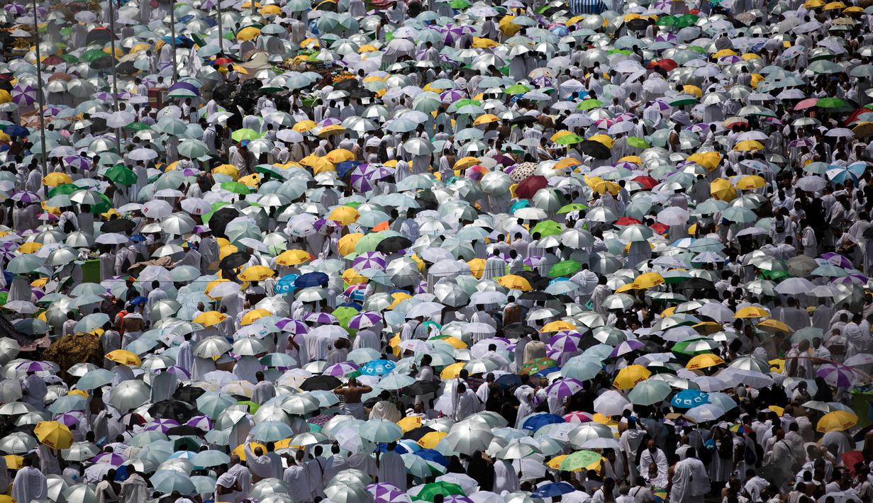Jemaah membawa payung saat memadati masjid Namirah di Kota Arafah, Arab Saudi (31/8). Menurut hikayat setempat, masjid ini merupakan salah satu saksi pertama kali Rasulullah melaksanakan ibadah haji. (AP Photo / Khalil Hamra)