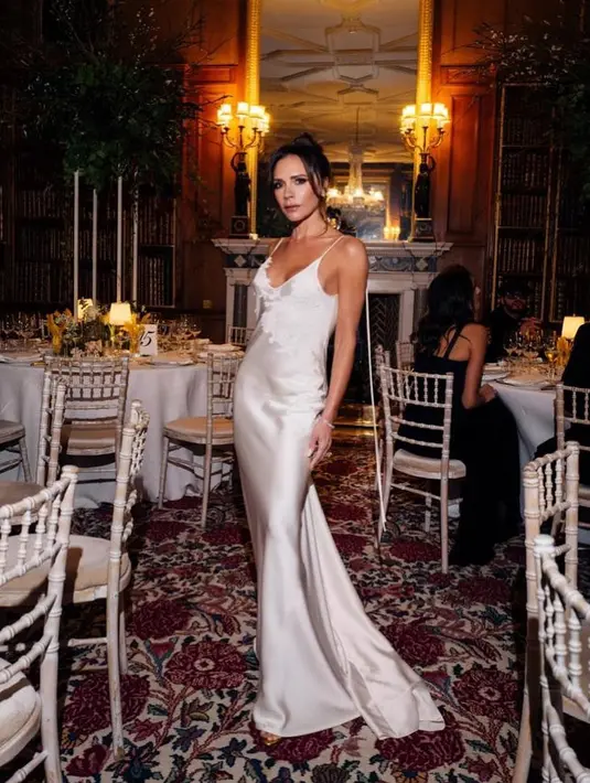 <p>Victoria Beckham tampak stunning dibalut dress berwarna broken white. Strappy dress ini memiliki detail kereta di belakangnya, membentuk tubuh Victoria dengan sempurna. Foto: Instagram.</p>
