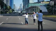 Dua orang wanita berfoto dengan latar belakang Jalan MH Thamrin yang masih ditutup oleh aparat keamanan di Jakarta, Jumat (24/5/2019). Ditutupnya Jalan MH Thamrin terkait unjuk rasa menolak hasil Pemilu 2019 dimanfaatkan sebagian warga untuk berfoto. (Liputan6.com/Immanuel Antonius)