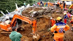 Petugas darurat mencari korban selamat setelah tanah longsor mengubur dua rumah di Mallama, Provinsi Narino, Kolombia, 2 November 2021. Sebanyak empat orang tewas dan beberapa dikhawatirkan terjebak menyusul longsor akibat hujan deras di daerah tersebut. (LEONARDO CASTRO/AFP)