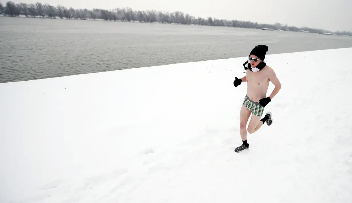 Seorang pelari ambil bagian dalam Underpants Run di tepi sungai Danube, Serbia pada 26 Januari 2019. Peserta berlari hanya dengan mengenakan pakaian dalam di tengah suhu yang mendekati 0 derajat Celcius. (AP/Darko Vojinovic)