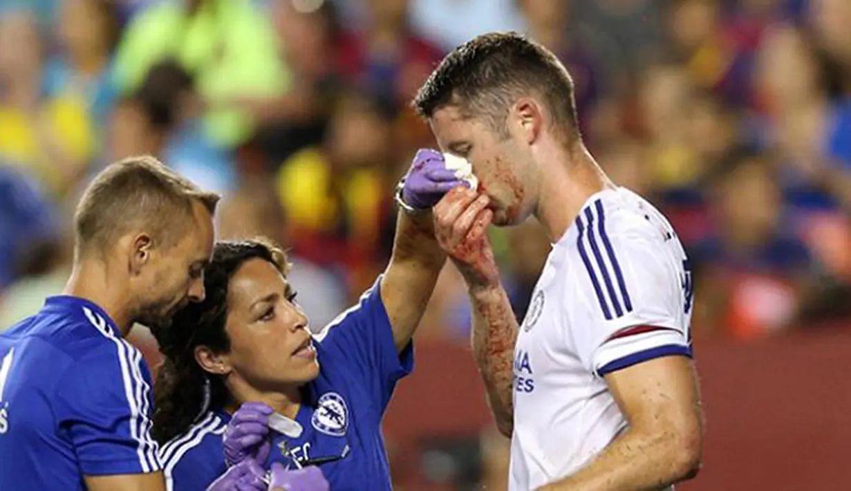 Pemain Chelsea Gary Cahill mendapatkan pengobatan dari tim medis akibat terluka karena duel udara saat mencetak gol pada Laga International Champions Cup di FedEx Field, AS, Rabu (29/7/2015) pagi WIB. (AFP Photo/Nicholas Kamm)