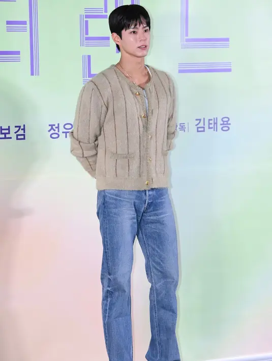 Cardigan dengan kancing emas tersebut dipadukan dengan celana denim panjang. Serta sepatu Celine model chelsea warna putih kulit buaya yang memiliki hak warna coklat.  [Celine]
