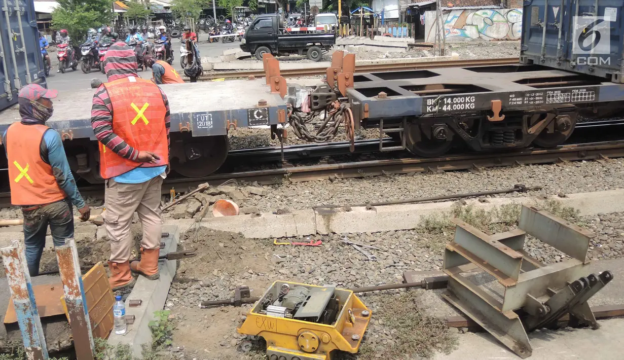 Kereta melintas saat pekerja PT KAI Daop 4 Semarang melakukan pengecekan sinyal di kawasan Stasiun Poncol, Semarang, Jawa Tengah, Rabu (12/12). Menyambut Natal, PT KAI Daop 4 Semarang menyediakan 44.348 tempat duduk setiap harinya. (Liputan6.com/Gholib)