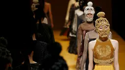 Sejumlah model mengenakan busana dari desainer asal Vietnam, Nguyen Cong Tri dalam koleksi Musim Autumn / Winter 2016 di Tokyo Fashion Week, Jepang , 15 Maret 2016. Uniknya dalam peragaan busana ini menggunakan topeng. (REUTERS / Issei Kato)
