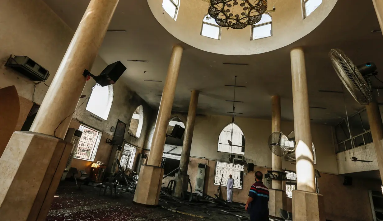 Dua pria memeriksa kerusakan masjid yang terkena serangan udara Israel di Kota Gaza, Palestina (15/7). Serangan ini dilakukan untuk membalas Hamas yang melakukan peluncuran roket dan mortir ke wilayah selatan Israel. (AFP  Photo/Mahmud Hams)
