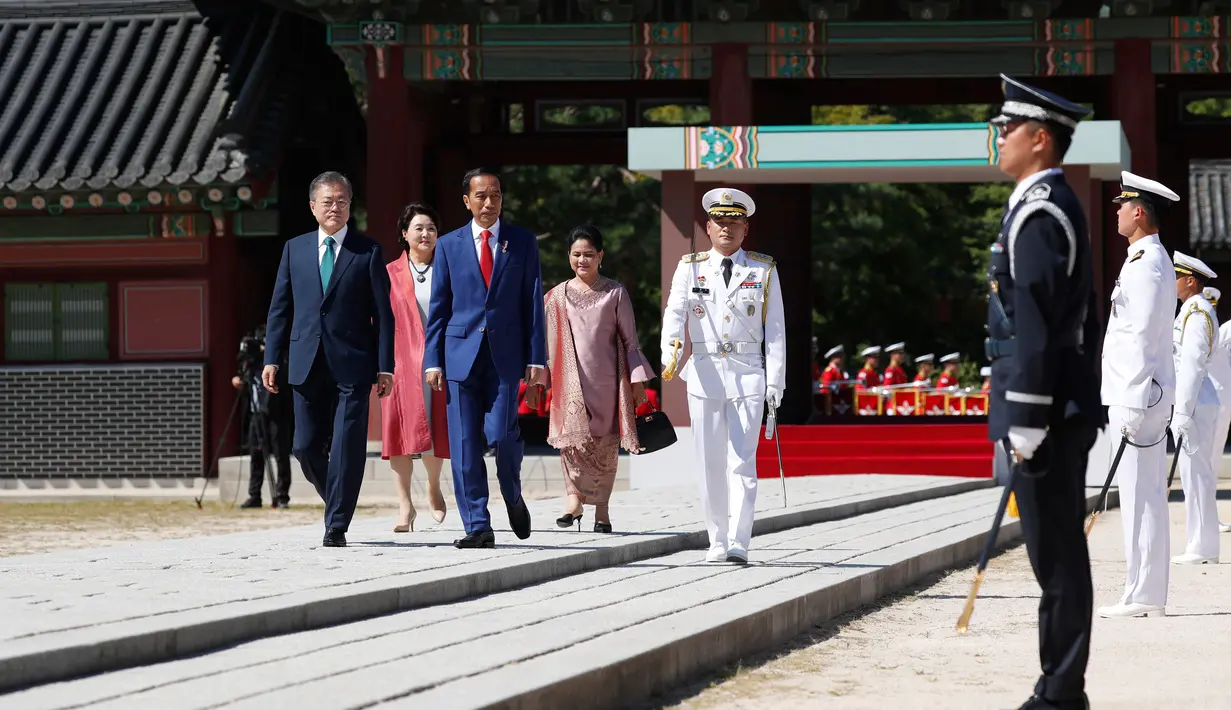 Presiden Jokowi dan Presiden Korea Selatan Moon Jae-in didampingi Ibu Negara Iriana Joko Widodo dan Ibu Negara Kim Jung-sook memeriksa penjaga kehormatan saat upacara penyambutan di istana Changdeokgung, Seoul, Senin (10/9). (Jeon Heon-kyun/Pool via AP)