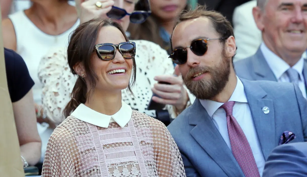 Pippa Middleton bersama adiknya, James Middleton, menyaksikan hari ketiga kejuaraan tenis Grand Slam Wimbledon 2017 di London, Rabu (5/7). Adik Kate Middleton itu menebar pesonanya dalam balutan dress pink berbahan menerawang.  (AP Photo/Tim Ireland)