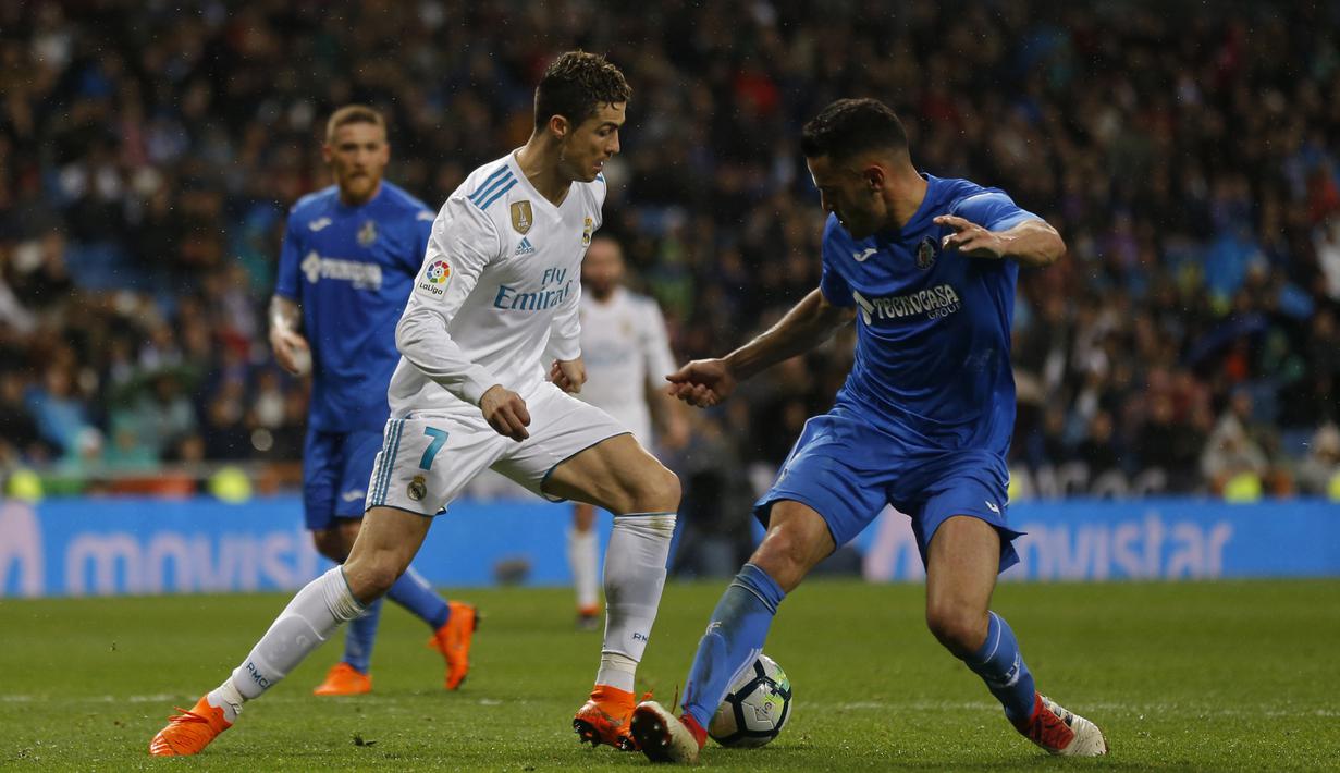 Cristiano Ronaldo (kiri) mengeoh pemain Getafe, Bruno Gonzalez pada lanjutan La Liga Santander di Santiago Bernabeu stadium, Madrid, (3/3/2018). Real madrid menang 3-1. (AP/Francisco Seco)