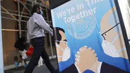 Seorang pria berjalan melewati sebuah iklan tentang perjuangan melawan COVID-19 di New York, AS (29/7/2020). Kematian akibat COVID-19 di AS telah menembus angka 150.000 pada Rabu (29/7), tepatnya 150.034 hingga pukul 15.35 waktu setempat atau Kamis (30/7) pukul 02.35 WIB. (Xinhua/Wang Ying)