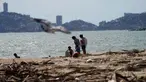 Warga setempat berjalan di pantai yang dipenuhi puing-puing setelah Badai Otis menerjang Acapulco, Meksiko, Kamis, 26 Oktober 2023. (AP Photo/Marco Ugarte)