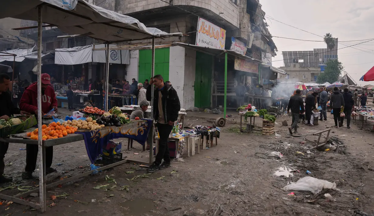 Suasana pasar pun mulai ramai dikunjungi warga yang membeli kebutuhan pokok, dan banyak toko kembali beroperasi. Tampak dalam foto, warga Palestina berjalan di sepanjang pasar jalanan tempat buah-buahan dan sayuran dipajang untuk dijual di Kota Gaza, Jumat, 19 Desember 2025. (AP Photo/Abdel Kareem Hana)