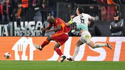 Pemain AS Roma, Romelu Lukaku mencetak gol kedua timnya ke gawang Brighton setelah memanfaatkan kesalahan Lewis Dunk (kanan) pada laga leg pertama 16 besar Liga Europa 2023/2024 di Olympic Stadium, Roma, Italia, Jumat (08/03/2024) dini hari WIB. (AFP/Andreas Solaro)