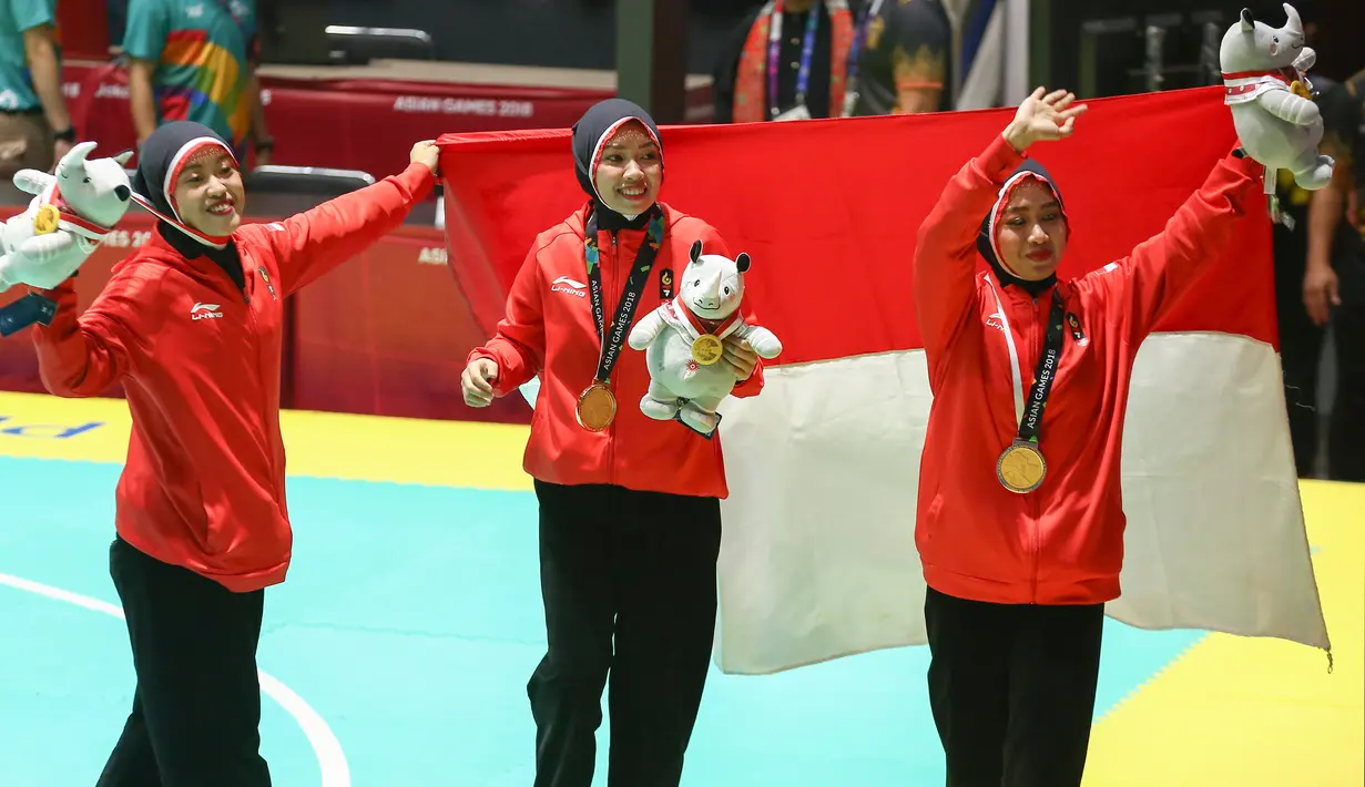 Tim pencak silat seni beregu putri Indonesia, Pramudita Yuristya (kiri), Lutfi Nurhasanah (tengah) dan Gina Tri Lestari (kanan) berselebrasi usai meraih medali emas Asian Games 2018, Jakarta, Rabu (29/8). (ANTARA FOTO/INASGOC/Melvinas Priananda/nak/18)