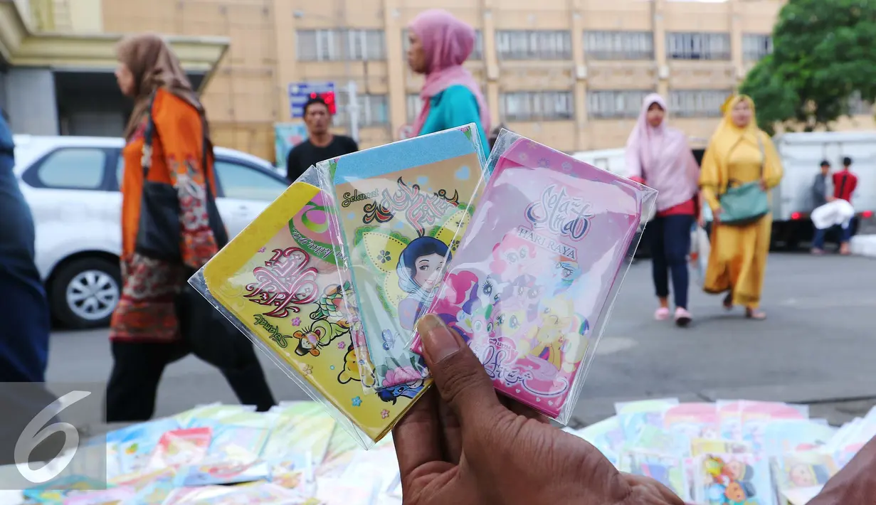 Pedagang memperlihatkan kartu ucapan selamat Idul Fitri di Tanah Abang, Jakarta, Selasa (28/6). Penjualan kartu ucapan tersebut alami penigkatan 100% karena menjadi incaran masyarakat untuk melengkapi hari raya lebaran. (Liputan6.com/Angga Yuniar)