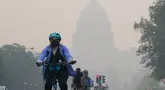 Seorang pengendara sepeda menggowes di bawah selimut kabut yang menutupi sebagian Capitol AS di Washington, DC, pada 8 Juni 2023. (Photo by Mandel NGAN / AFP)