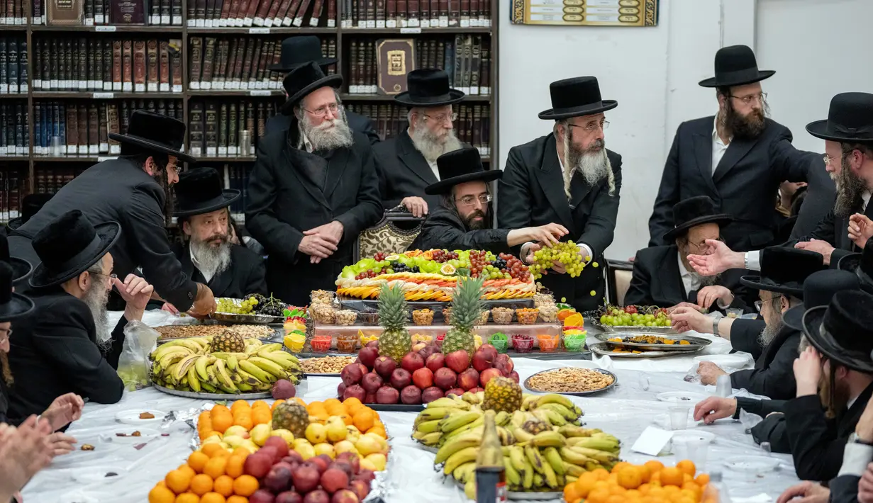 Orang-orang Yahudi Ultra-Ortodoks merayakan Hari Raya Yahudi Tu Bishvat atau Tahun Baru Pohon di Yerusalem, 5 Februari 2023. Saat perayaan Tahun Baru Pohon, orang-orang Yahudi Ultra-Ortodoks berkumpul dengan para rabi mereka di sekitar meja panjang berisi piring-piring berisi beberapa jenis buah-buahan. (AP Photo/Ohad Zwigenberg)
