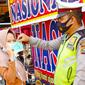 Personel Direktorat Lalu Lintas Polda Riau bagikan masker kepada penggendara saat Operasi Zebra. (Liputan6.com/M Syukur)