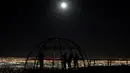 Sejumlah orang berfoto sambil menyaksikan fenomena Supermoon dari sebuah dataran tinggi di Ciudad Juarez, Meksiko, Minggu (16/10). Fenomena ini terjadi setiap tahun ketika orbit bulan berada berada dekat dengan bumi. (Reuters/Jose Luis Gonzalez)