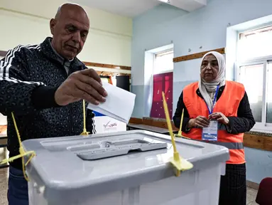 Seorang pria Palestina menggunakan hak politiknya di Tempat Pemungutan Suara (TPS) selama pemilihan kota di Al-Bireh, Tepi Barat yang diduduki Israel, pada Sabtu 25 April 2026. Warga Palestina di Tepi Barat yang diduduki Israel menggunakan hak politik mereka dalam pemilihan kota (pemilu lokal). (Zain JAAFAR/AFP)