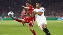 Thomas Mueller (kiri) mencoba menghalau bola dari kejaran pemain Sevilla, Luis Muriel pada leg kedua perempat final Liga Champions di Allianz Arena stadium, Munich, (11/4/2018). Bayern lolos ke semifinal dengan agregat 2-1. (AP/Matthias Schrader)