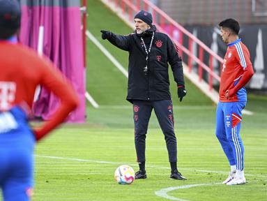 Pelatih baru Bayern Munchen, Thomas Tuchel memberi isyarat di sebelah Joao Cancelo saat sesi latihan pertamanya di Munich, Jerman, Selasa (28/3/2023). (Sven Hoppe/dpa via AP)