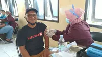 Salah seorang wartawan online nasional tengah menjalani vaksinasi Covid-19 di Aula PWI Garut, Jawa Barat. (Liputan6.com/Jayadi Supriadin)