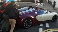 Pemilik Bugatti terpaksa turun dari mobil dan meminta kepada pemuda yang ada di sekitarnya untuk membantu mendorong mobil.