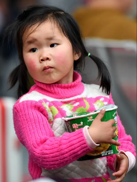 Seorang anak menunggu kereta api di Stasiun Kereta Selatan Guangzhou saat arus mudik Tahun Baru Imlek di Guangzhou, Provinsi Guangdong, China selatan (16/1/2020). Tahun Baru Imlek jatuh pada 25 Januari tahun ini. (Xinhua/Liu Dawei)