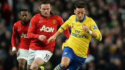 Gelandang Arsenal Mesut Ozil (kanan) berebut bola dengan Wayne Rooney saat pertandingan sepak bola Liga Inggris antara Manchester United melawan Arsenal di Stadion Old Trafford, Manchester (10/11/13) waktu setempat (Foto: AFP/Paul Ellis)
