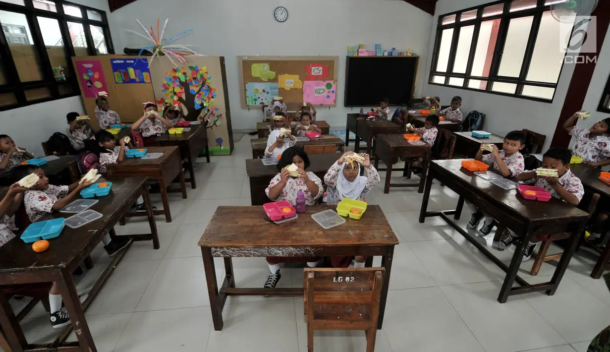 Siswa menyantap makanan tambahan saat program PMTAS di SD Negeri 01 Tanjung Priok, Jakarta, Kamis (28/3). Setiap anak mendapatkan makanan tambahan senilai Rp 10.800 setiap hari (pagi atau siang) dengan varian menu seperti buah-buahan, roti dan susu UHT. (merdeka.com/Iqbal S. Nugroho)