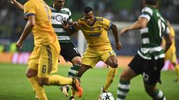 Bek Juventus, Alex Sandro, berusaha melewati kepungan pemain Sporting CP pada laga Liga Champions di Stadion Jose Alvalade, Lisbon, Selasa (31/10/2017). Kedua klub bermain imbang 1-1. (AFP/Patricia De Melo Moreira)