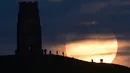 Sejumlah warga menyaksikan fenomena supermoon di Glastonbury, Inggris (13/11). Fenomena ini merupakan bulan paling besar dan terang dalam kurun 70 tahun terakhir. (REUTERS/Rebecca Naden)