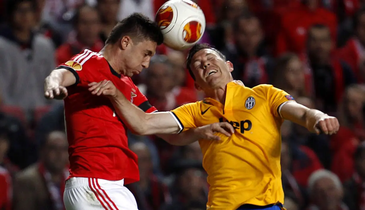 Pemain Benfica, Guilherme Siqueira (kiri) berebut bola atas dengan Stephan Lichtsteiner (Juventus) dalam laga pertama semifinal Liga Europa di stadion Luz, Lisbon (25/4/2014). (REUTERS/Rafael Marchante)