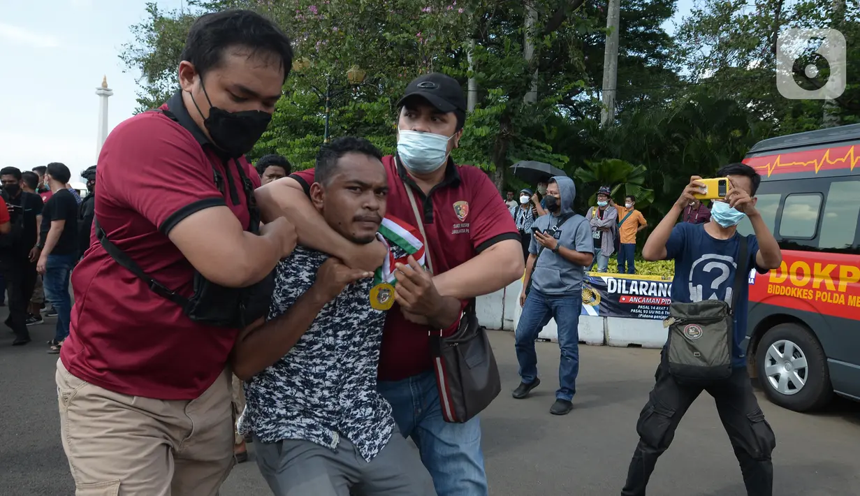 Aparat kepolisian mengamankan seorang pria saat unjuk rasa memperingati May Day atau Hari Buruh di kawasan Patung Kuda, Jakarta, Sabtu (1/5/2021). Polisi mengamankan sejumlah massa yang diduga mahasiswa dalam aksi unjuk rasa tersebut. (merdeka.com/Imam Buhori)