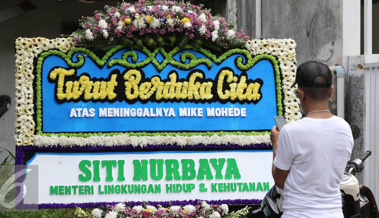 Karangan bunga dari Menteri LHK, Siti Nurbaya terpampang di rumah duka Mike Mohede di kawasan Tangerang Selatan, Banten, Senin (1/8). Mike Mohede meninggal dunia di usia 32 tahun karena serangan jantung. (Liputan6.com/Herman Zakharia)